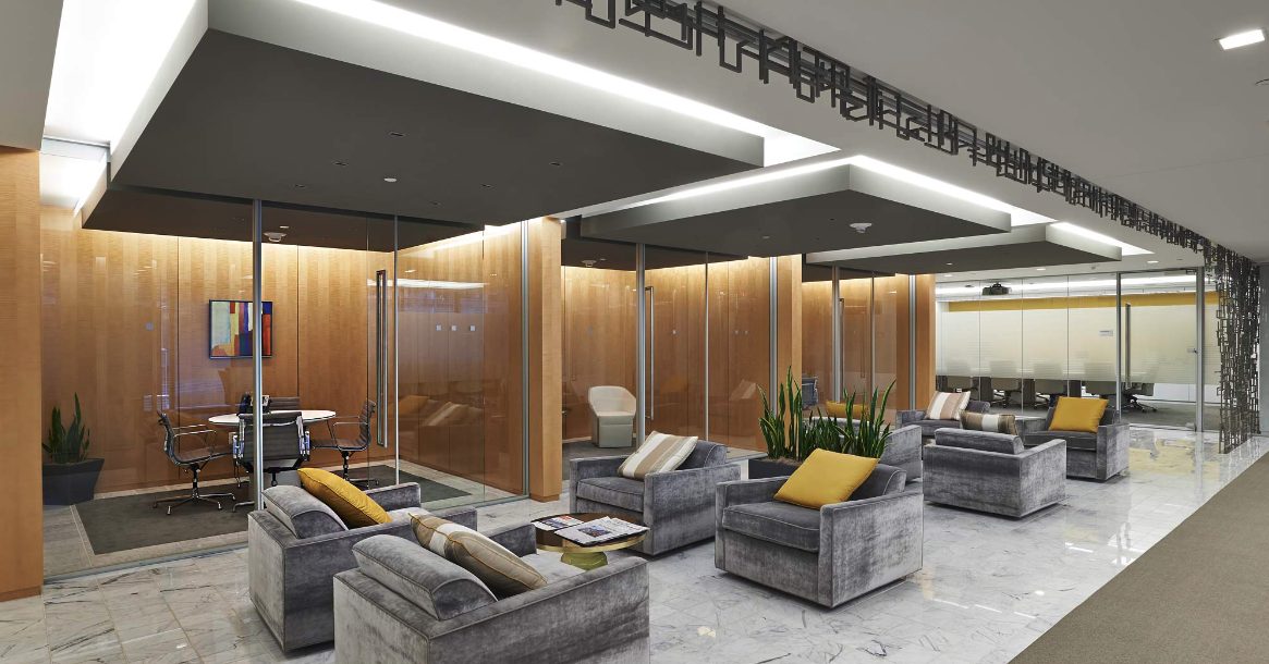 Adotta glass partitions and plush seating in a modern office lobby